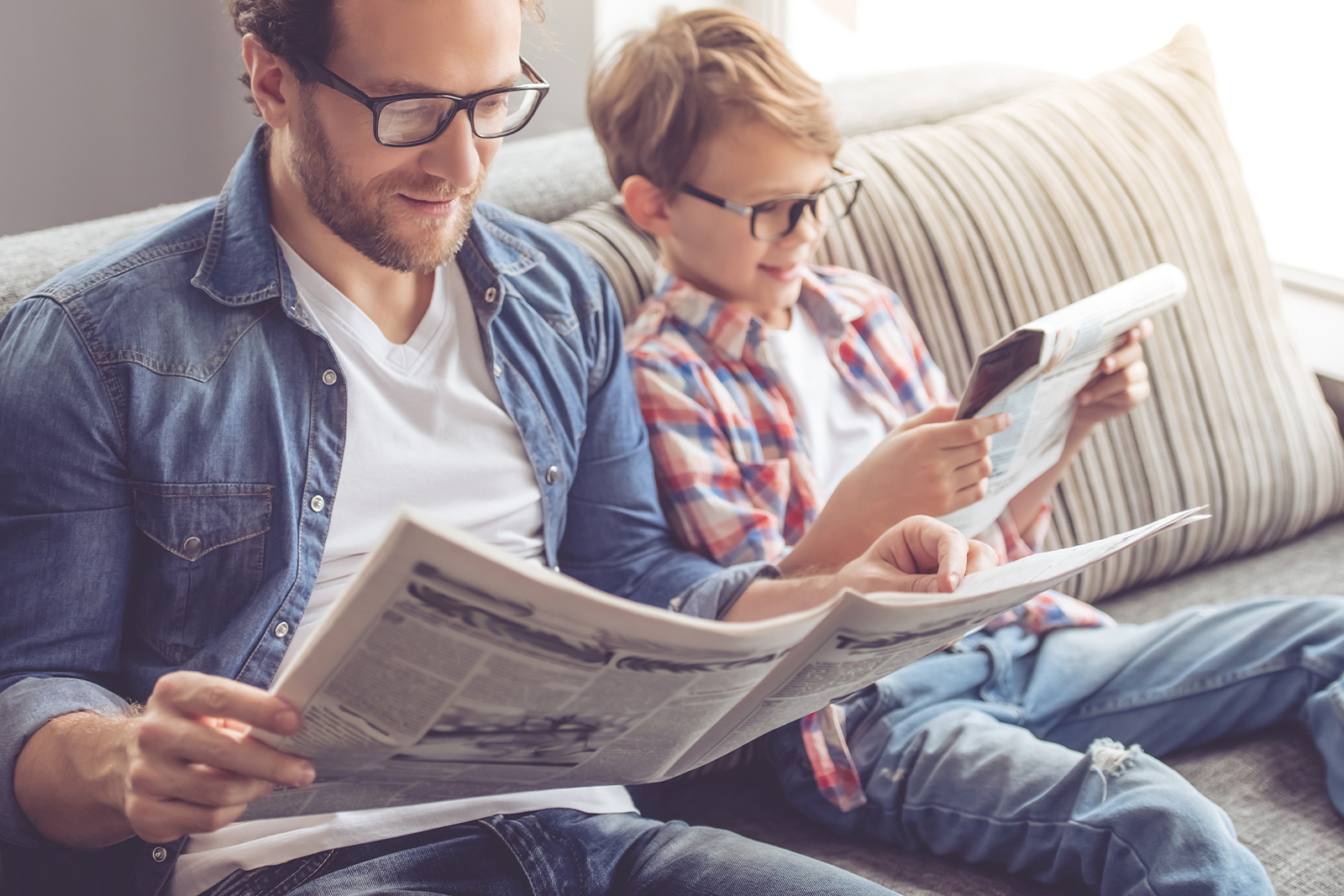 Vater und Sohn lesen zusammen Zeitung
